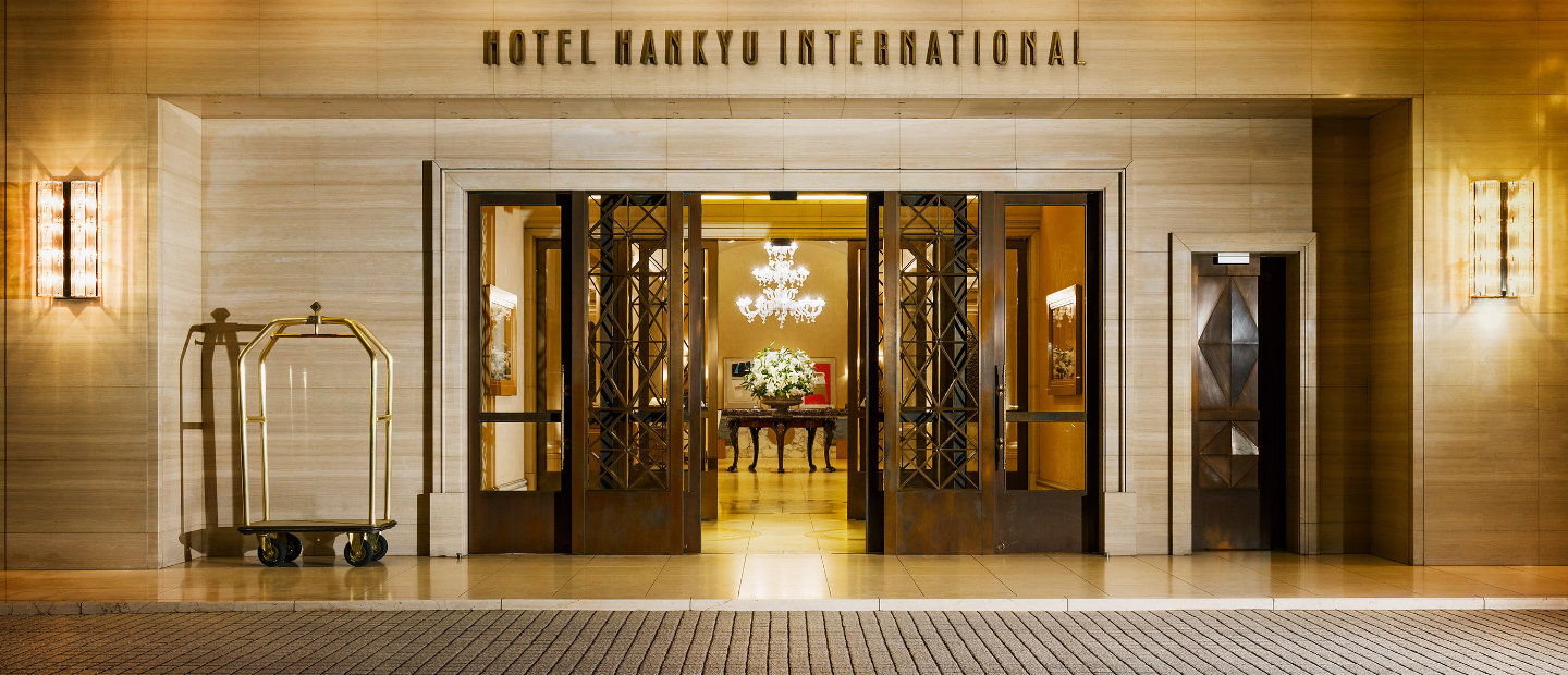 Elegant wide entrance of Hotel Hankyu International Osaka at night lightened golden