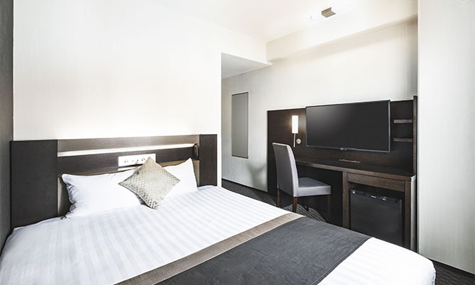 ダブルルームのベッドとテレビ